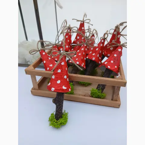 Rote Deko-Pilze mit weißen Punkten, Holzstielen und Juteschleifen