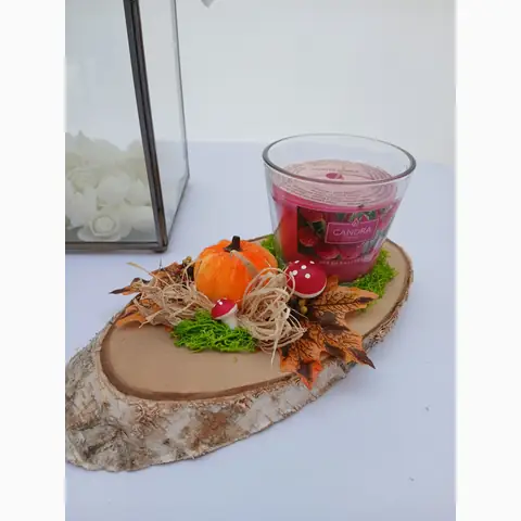 Herbstgesteck auf einer Holzscheibe mit Kerze, Kürbis und kleinen Pilzen