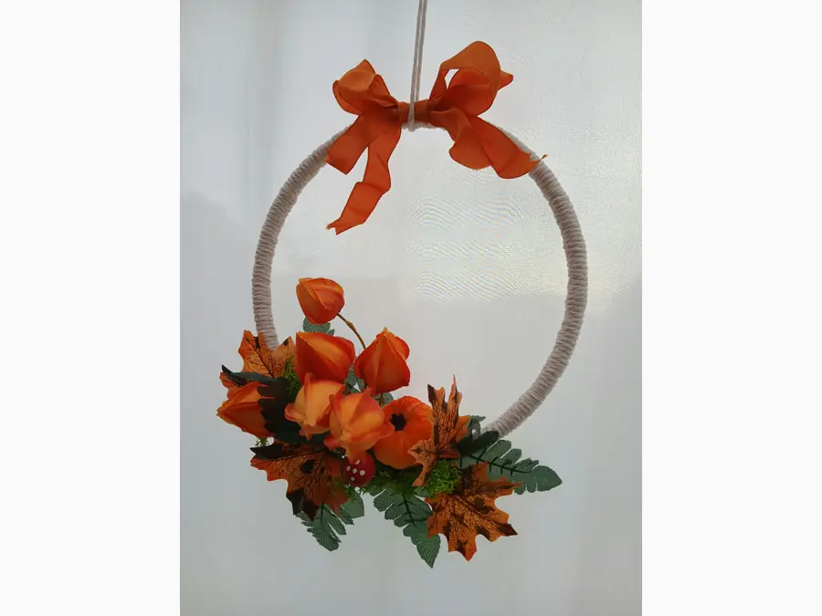 Herbstlicher Dekoring mit orangefarbener Schleife und Physalis