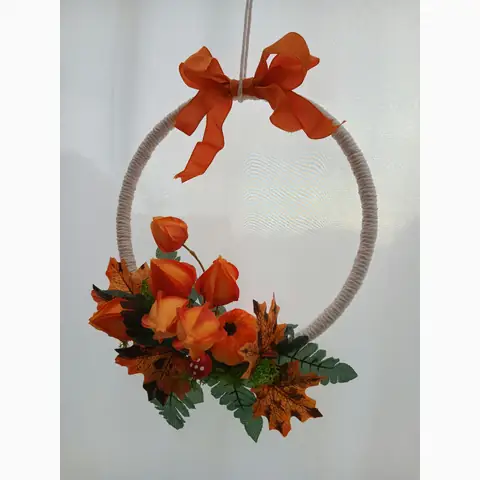 Umwickelter Dekoring mit orangefarbener Schleife, Physalis und Herbstblättern
